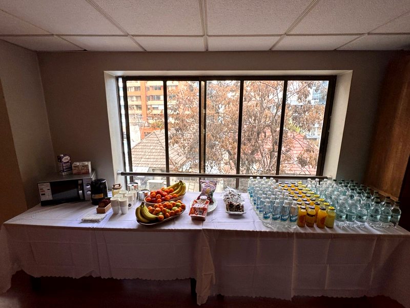 Mesa del coffee break con fruta, café, jugos y agua
